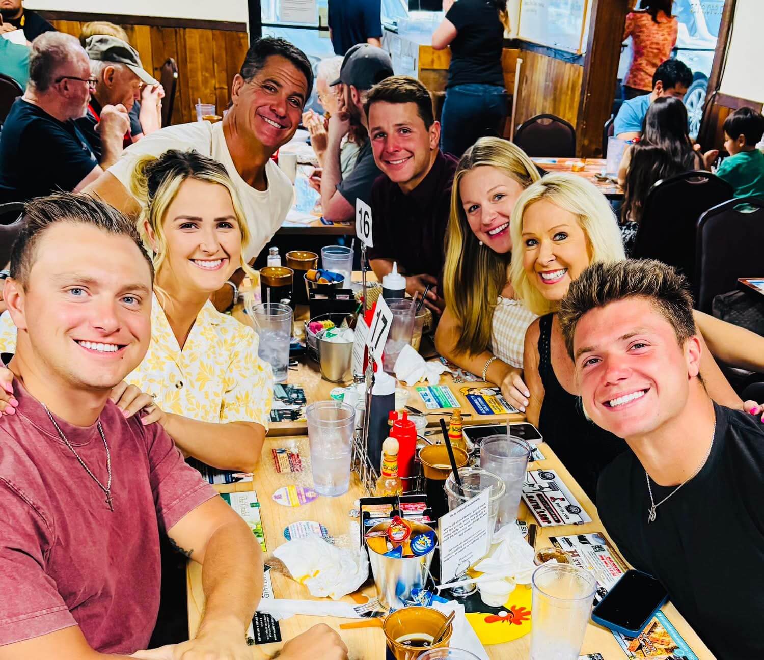 Group of people smiling at a restaurant.